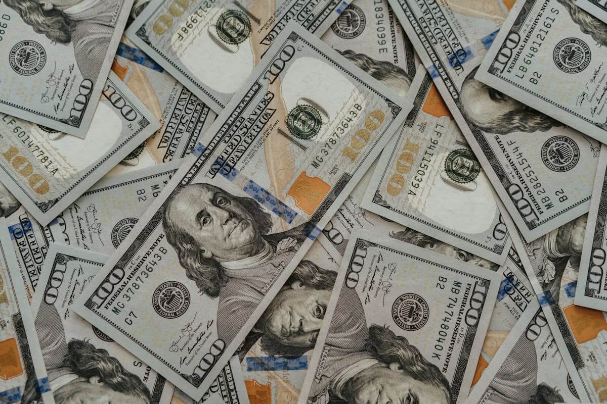 Pile of hundred-dollar bills representing government relief funds and financial support through the Stimulus Check 2025 program.
