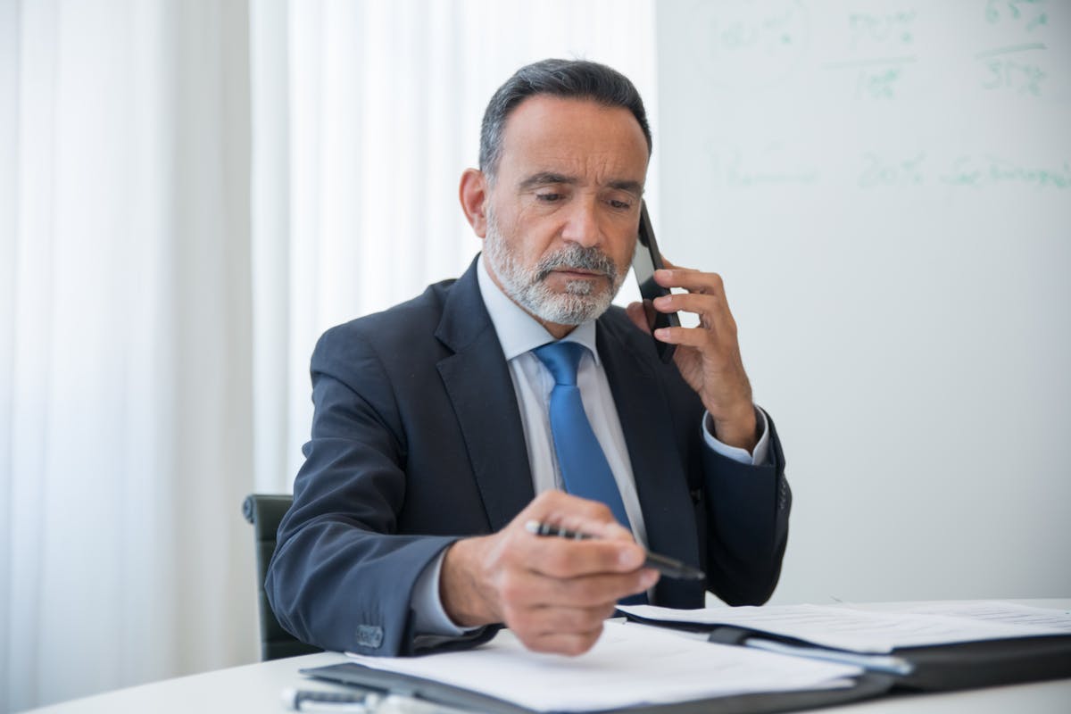 Guide on how to file IRS Form 1040-X shown by a consultant working through papers at a workstation.