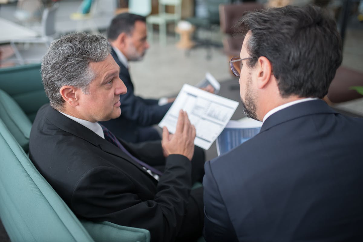 Advisor explaining the nonprofit compliance checklist to a colleague with printed charts.