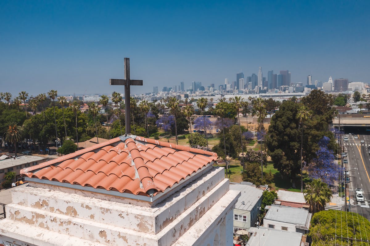 Cityscape behind a church cross, illustrating nonprofits exempt from Form 990 guidance.