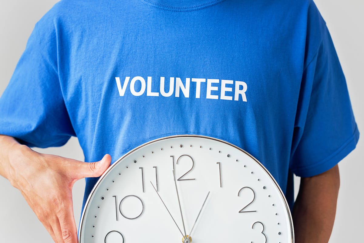 Guide on nonprofits need to register in every state they fundraise in is depicted by a volunteer holding a wall clock.