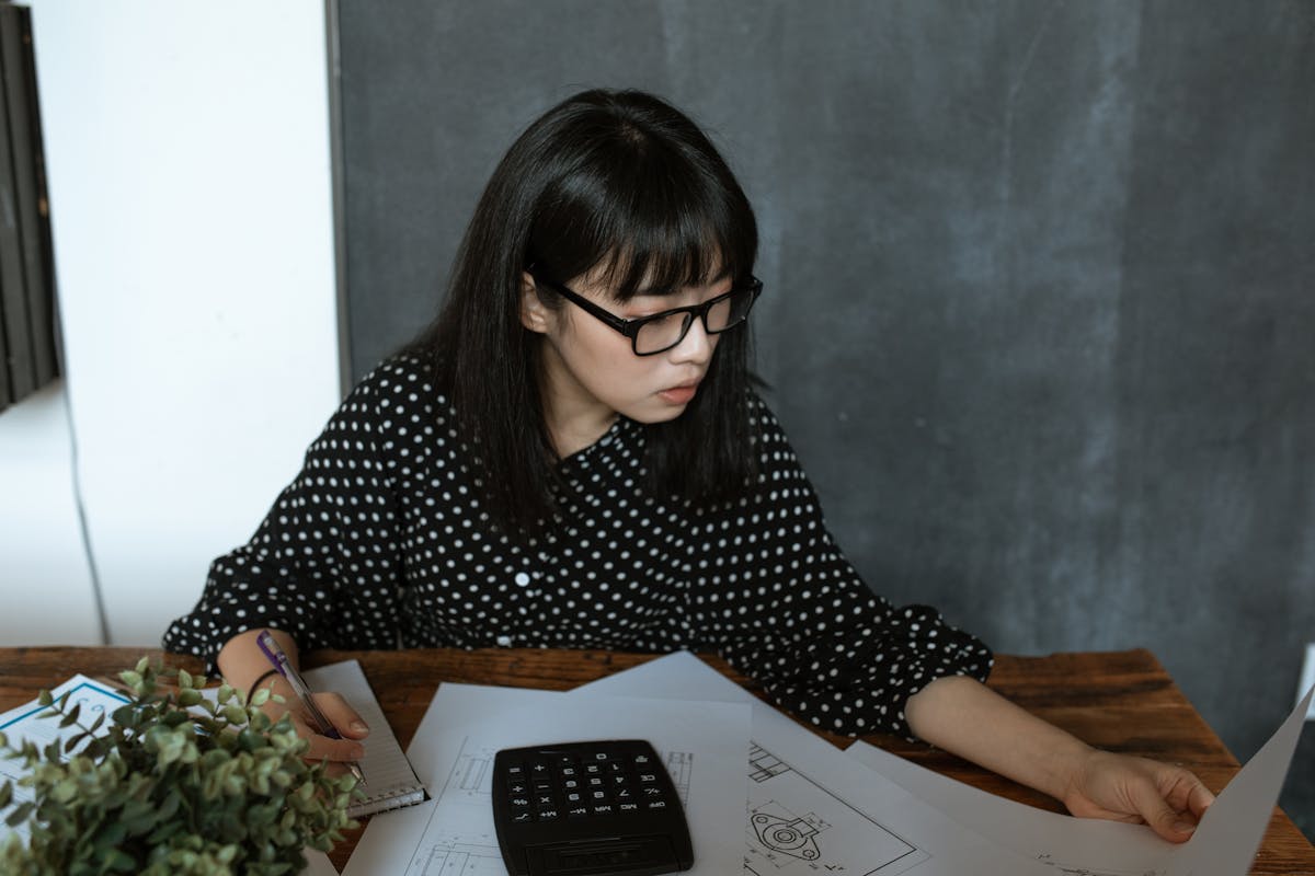 Consequences of not filing IRS Form 8854, depicted by someone calculating taxes at a desk.