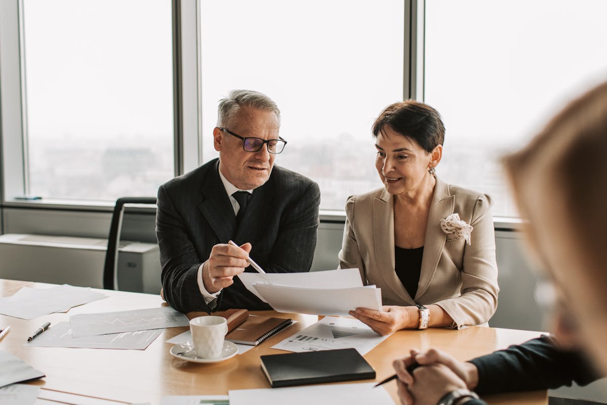 Business advisors examining forms in a bright office, ideal for ‘When to file Form 8854’ articles.