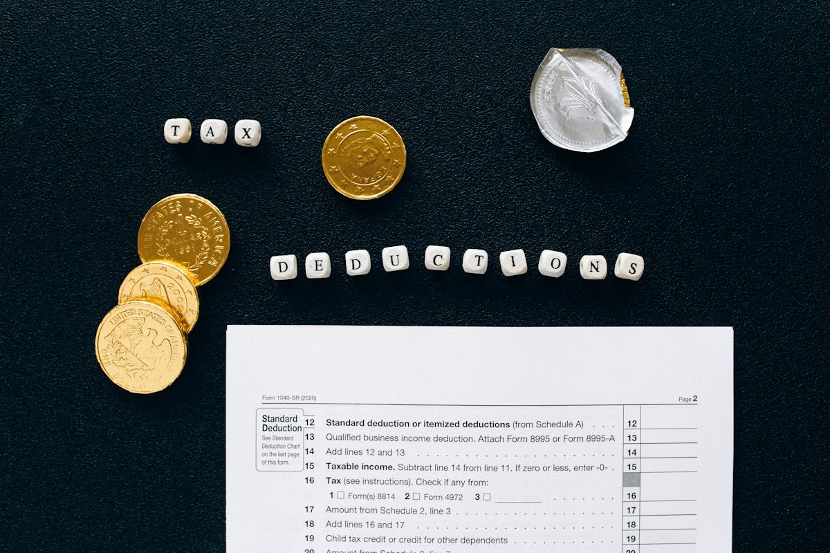 Calculating itemized deductions shown by a tax return page, coins, and word tiles.