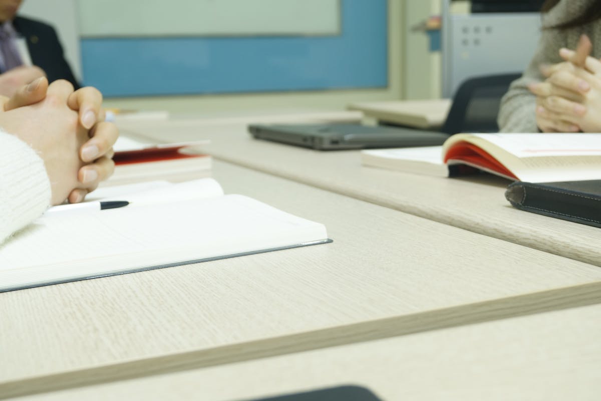 Guide to withdraw from 401(k) without penalty shown by coworkers seated at a table with paperwork.
