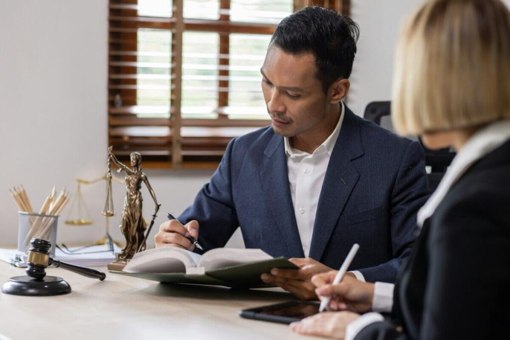 A man in a suit writing on a notebook. Providing an Estate & Probate Support to a client.